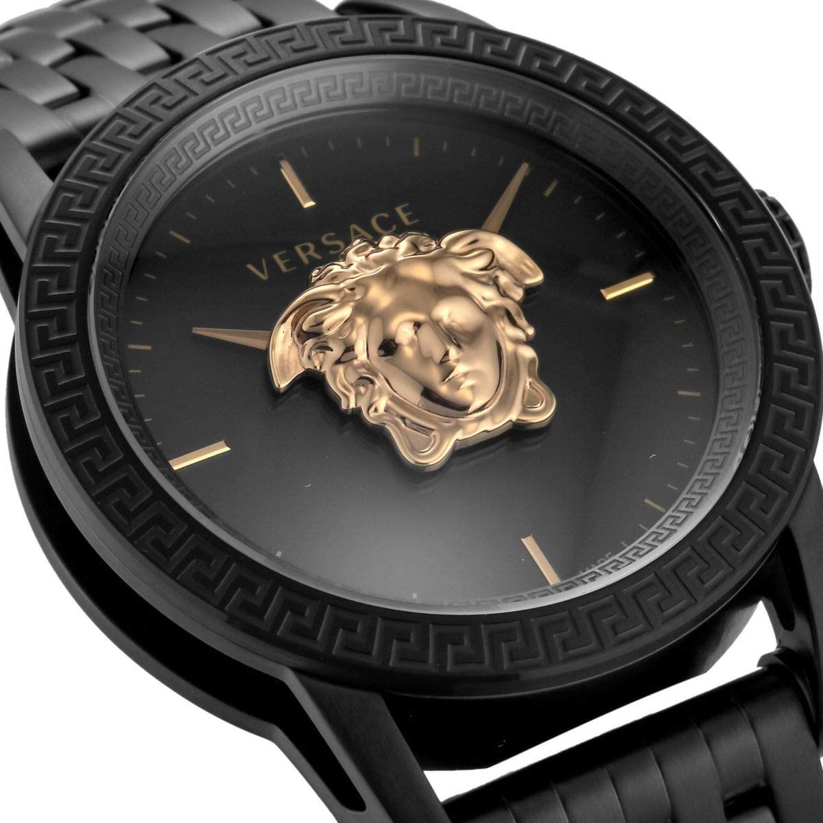 Close-up of black dial with gold Medusa head and gold hour markers